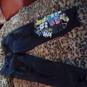 Black ripped jeans with LOVE notes on left lower leg
